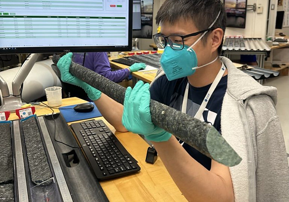 El científico Kuan-Yu Lin (Universidad de Delaware, EE. UU.) estudia las rocas del manto recuperadas a bordo del JOIDES Resolution durante la Expedición 399 del IODP