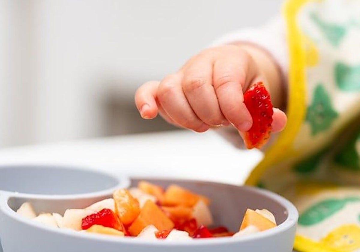 En la imagen un bebé usa el agarre de pinza para coger un objeto pequeño