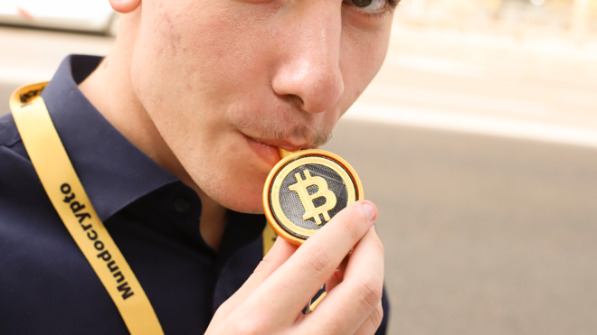 Un inversor y extrabajador de Mundo Crypto con una boquilla para la cachimba con el logo de Bitocin