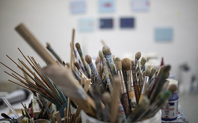 Imagen principal - Arriba, detalle de los pinceles del pintor en su estudio. Sobre estas líneas, Mitsuo, durante el montaje de su muestra en el Palacio de Cristal en 2013 y en una imagen de archivo en los setenta