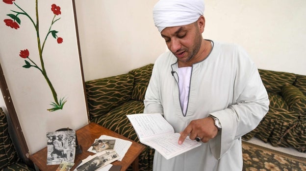 Mostafa Abdo Sadek lee sus notas sobre excavaciones durante la entrevista en Saqqara