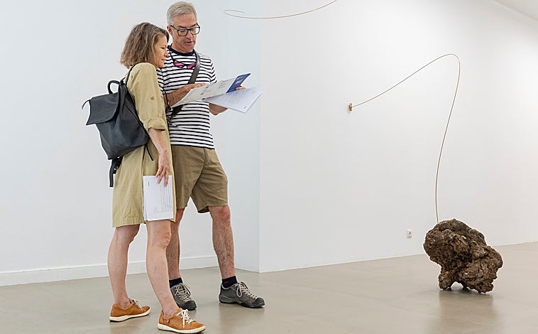 Imagen principal - Sobre estas líneas, obras de Guillermo Pérez Villalta (Sala Parés) y Jean Denant (Rocía SantaCruz). Arriba, dos personas contemplan las delicadas propuestas de Joana Escoval en Bombón