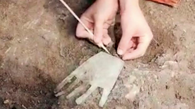 Extrayendo la mano de la tierra