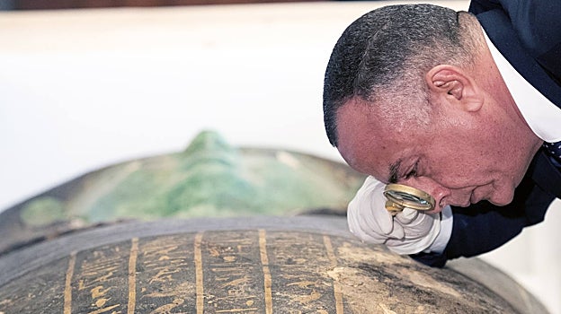 Mostafa Waziri, director del Consejo Supremo de Antigüedades, observa los jeroglíficos del sarcófago