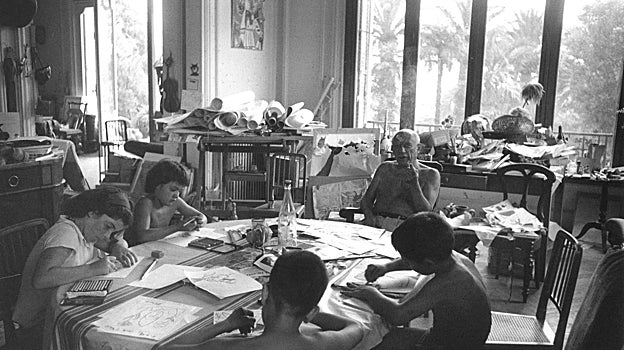 Picasso, en La Californie, su casa de Cannes, con sus hijos, pintando en la mesa
