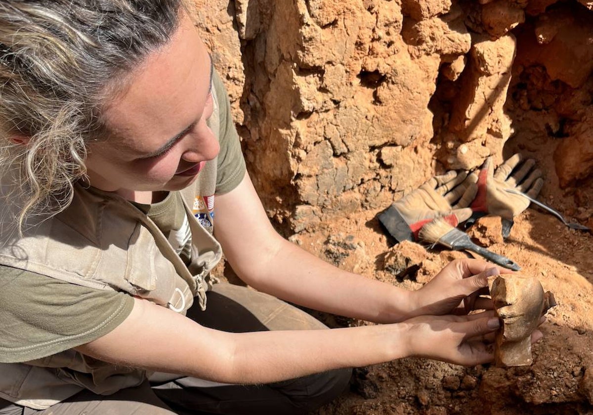 La arqueóloga Laura Salguero, tras desenterrar un fragmento de una de las figuras