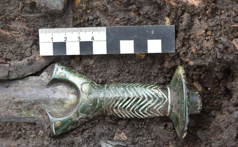 Imagen principal - La espada de bronce formaba parte del ajuar funerario hallado en una sepultura donde fueron enterradas tres personas