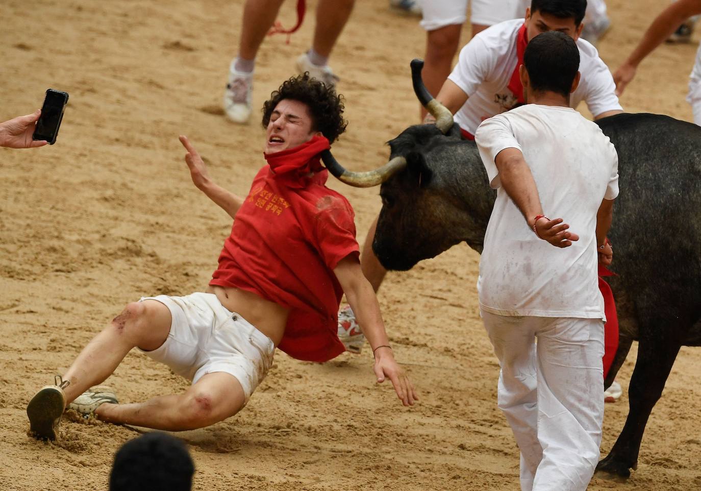 Un participante es derribado por una vaca joven después del "encierro" de las fiestas de San Fermín en Pamplona 