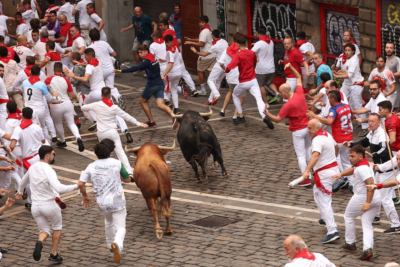 Parte de la carrera del quinto encierro de las fiestas de San Fermín en Pamplona
