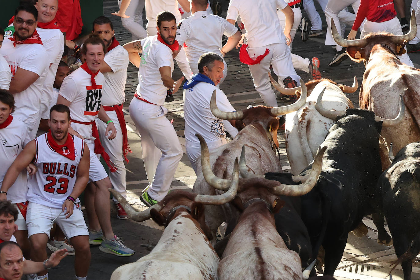 Mozos perseguidos de cerca por toros de la ganadería extremeña Jandilla durante el sexto encierro de Sanfermines
