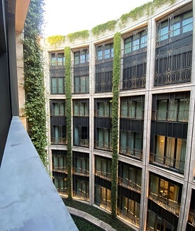 Imagen secundaria 2 - De arriba abajo: el hall del hotel, un detalle del minibar y la vista a los jardines verticales desde la habitación