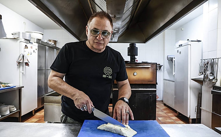 Imagen principal - Chimo Bayo cortando el bacalao en la primera foto. En la segunda, muestra su anillo 'hu-ha'; en la última, con el dueño del restaurante 'El rey del bacalao'