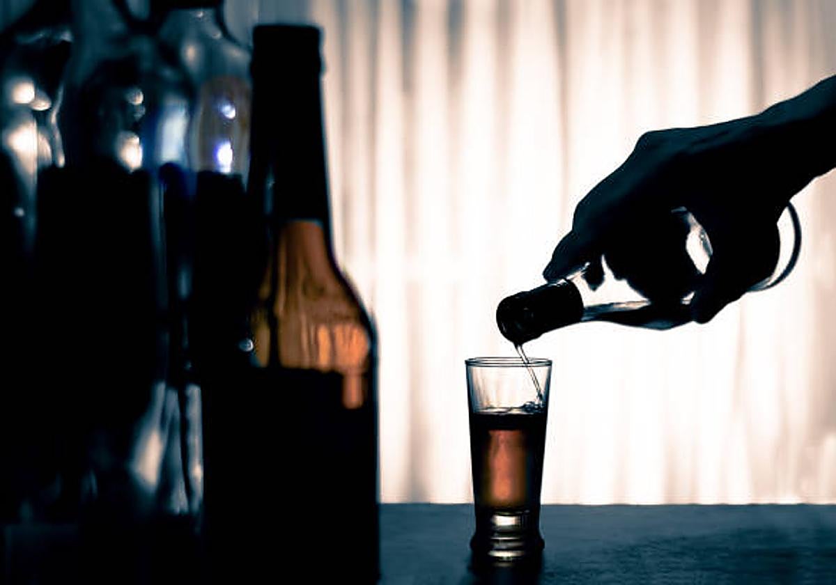 Una persona se prepara una copa de alcohol