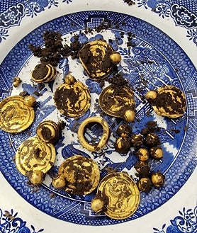 Imagen secundaria 2 - Los medallones y perlas hallados formarían un magnífico collar. Abajo, anillos de oro e imagen de las piezas tras ser desenterradas