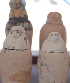 Imagen secundaria 2 - Mustafá Waziri, durante la conferencia de prensa que reveló el hallazgo de la necrópolis. Abajo, ushebtis y vasos canopos descubiertos 