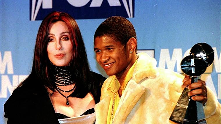 Usher posa junto a Cher tras recibir el premio Billboard a Artista del Año en 1998