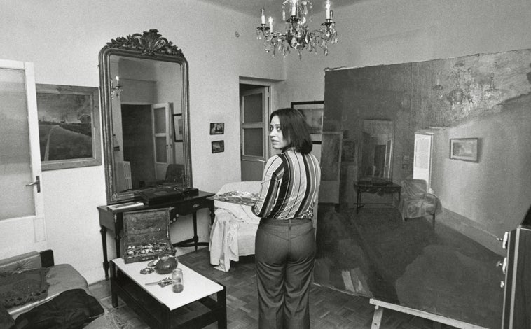 Imagen principal - Arriba, Isabel Quintanilla pintando 'Gran interior' (1973). Sobre estas líneas, a la izquierda, los miembros del grupo de realistas de Madrid (de izquierda a derecha y de abajo arriba, Antonio López, Amalia Avia, Esperanza Moreno, Francisco López Hernández, María Moreno, Isabel Quintanilla y Julio López Hernández); a la derecha, 'Autorretrato' (1962), de Isabel Quintanilla (Colección privada)