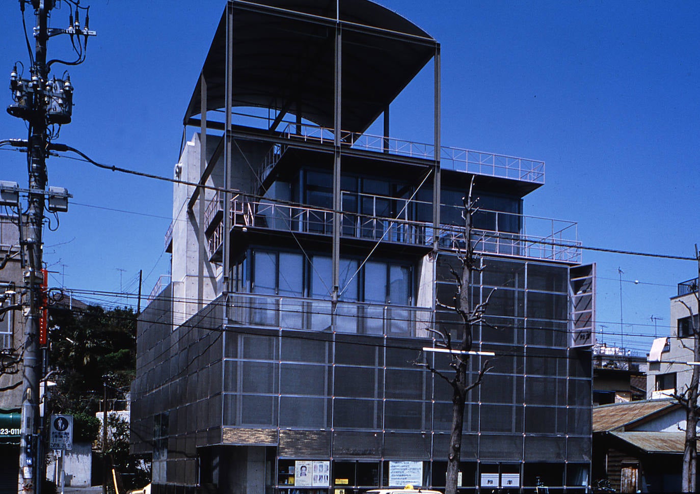  GAZEBO, Yokohama (Japón), 1986.  «Esta es mi propia casa. Siempre me levanto hacia las 6.30, doy de comer a los peces y limpio el arenero de los gatos. Hago zumo de manzana, naranja y repollo. Puedo ver la azotea de la casa a través del callejón cuando doy de comer a los peces porque el estanque está en la terraza de la cuarta planta. La azotea del edificio de tres pisos al otro lado del callejón está repleta de plantas. Cada mañana saludo a la anciana que riega esas plantas o cuelga la ropa. Empieza a hacer calor, ¿verdad? También saludo a la señora que cuelga la colada en la azotea que hay dos casas más allá. La vida diaria de la comunidad local transcurre a cuatro pisos sobre el suelo».