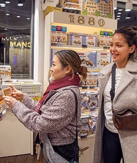 Imagen secundaria 2 - Arriba: Loewi Lin y Robert Rearden en el restaurante michelín Disfrutar. Izquierda: La familia Riley paseando por Las Ramblas. Derecha: La familia Riley dentro del establecimiento de Turrones Vicens