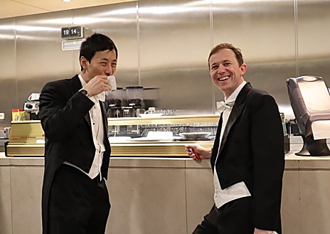 Imagen secundaria 1 - Loewi Lin se corta las uñas antes del concierto y se toma un café para no perder las fuerzas junto a un compañero mientras otros miembros de la orquesta se van preparando 