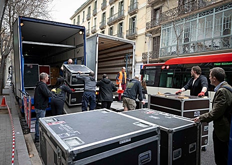 Imagen secundaria 1 - Arriba e izquierda: El equipo técnico de la NSO descarga los instrumentos en la puerta del Palau de la Música Catalana, mientras que en la derecha lo descarga en el Auditorio Nacional de Madrid