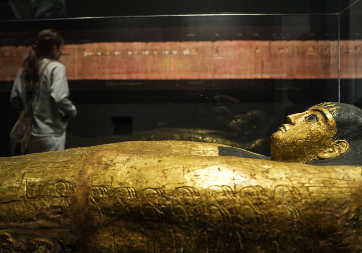 Detalle de una de las piezas de la exposición con el papiro de Ani en segundo plano