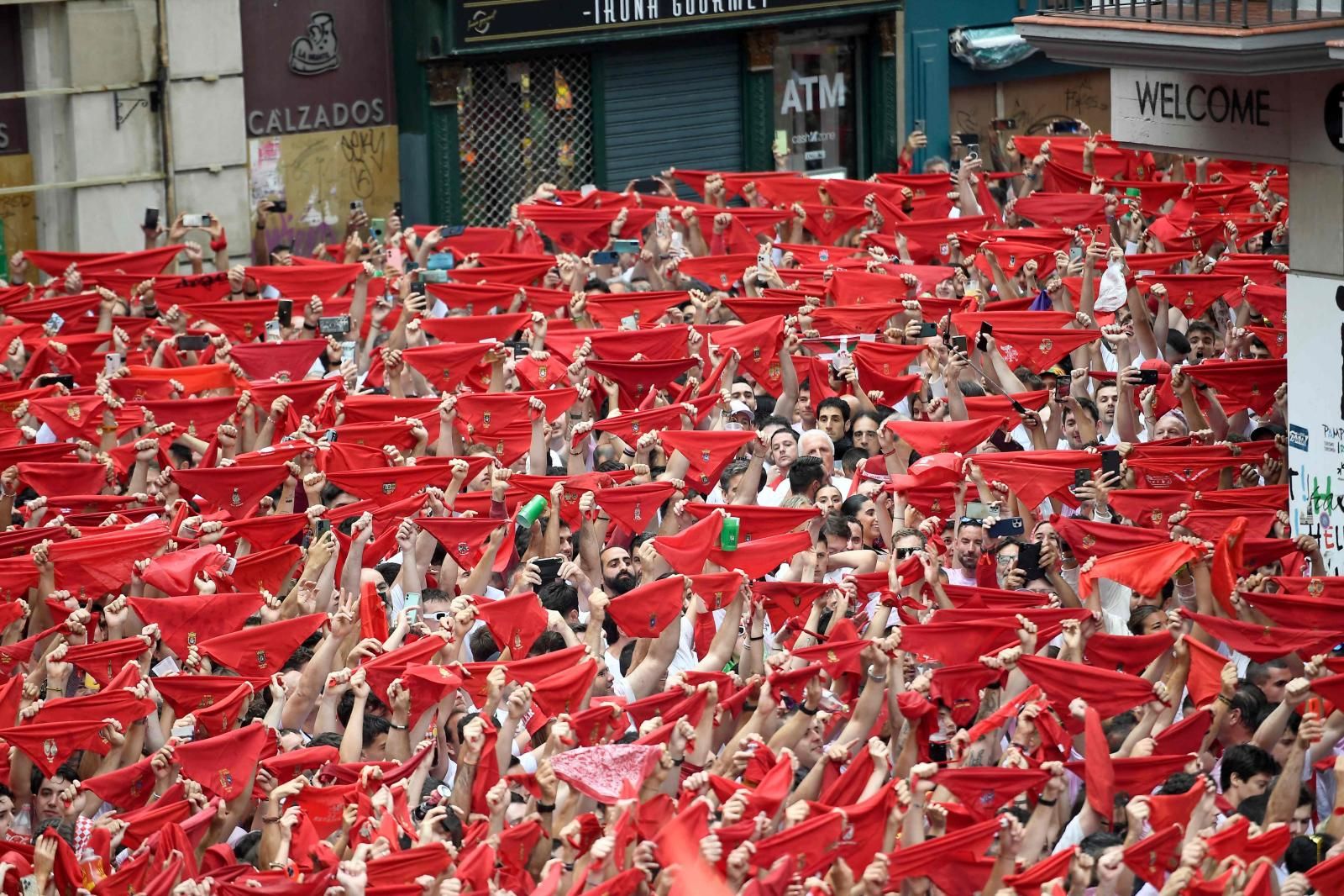 Miles de aficionados a San Fermín, alzando el pañuelo rojo, el atuendo pamplonica imprescindible para estos días.