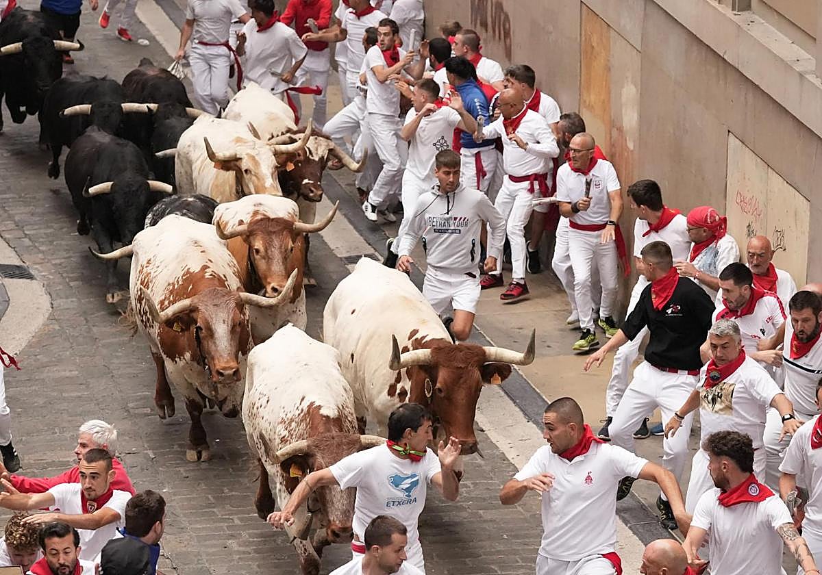 Mozos son perseguidos por toros de Victoriano del Río en el tercer encierro de los Sanfermines este martes, en Pamplona
