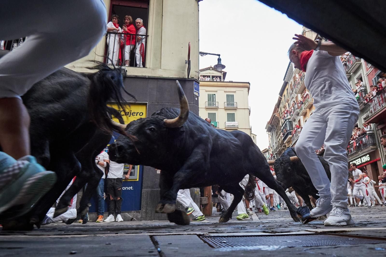 Un mozo al lado de tres toros de Jandilla  en el sexto encierro de San Fermín