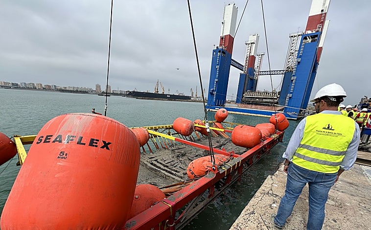 Imagen principal - El pecio, durante su extracción y depósito en el muelle