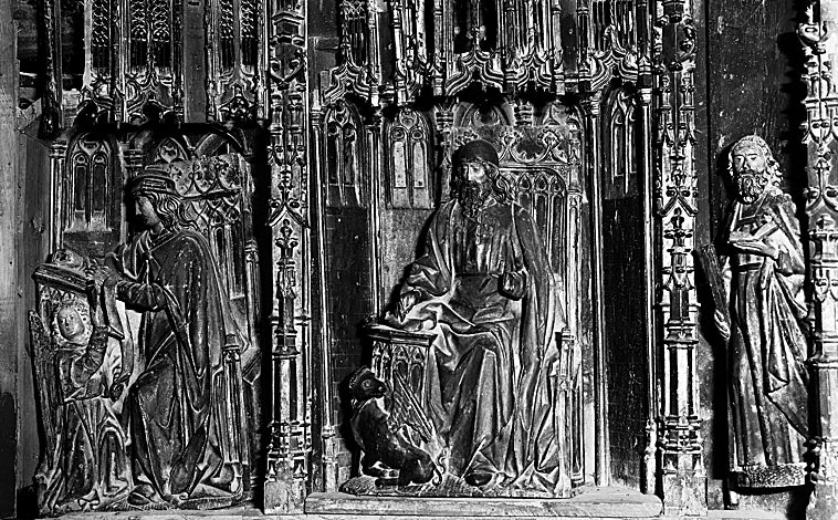 Imagen principal - Fotografía antiguas del retablo del que fueron robadas las figuras de tres evangelistas de la predela, entre ellos, el San Lucas (dcha). A la izquierda, Pedro Ramón Jiménez y María Elizari muestran a ABC el catálogo donde aparecía a la venta la pieza.