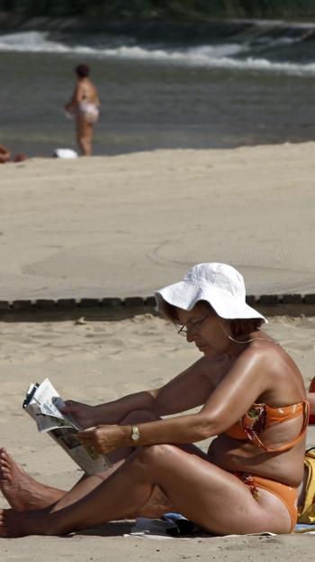 Una mujer lee en la playa