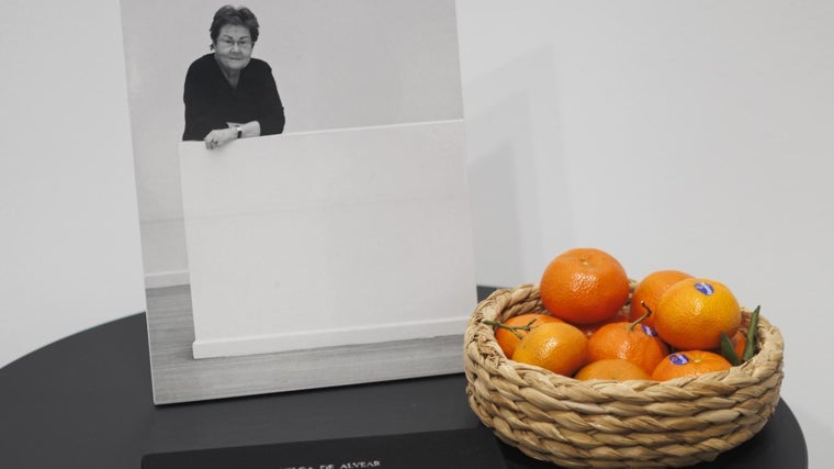 Una foto de Helga de Alvear, junto a un cesto de mandarinas, en el estand de la galerista fallecida