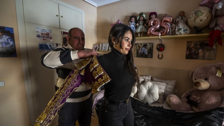 Enrique, el padre de Estrella, le pone una chaquetilla nazarena y oro en su habitacion, con muñecas, peluches y fotos de toreros