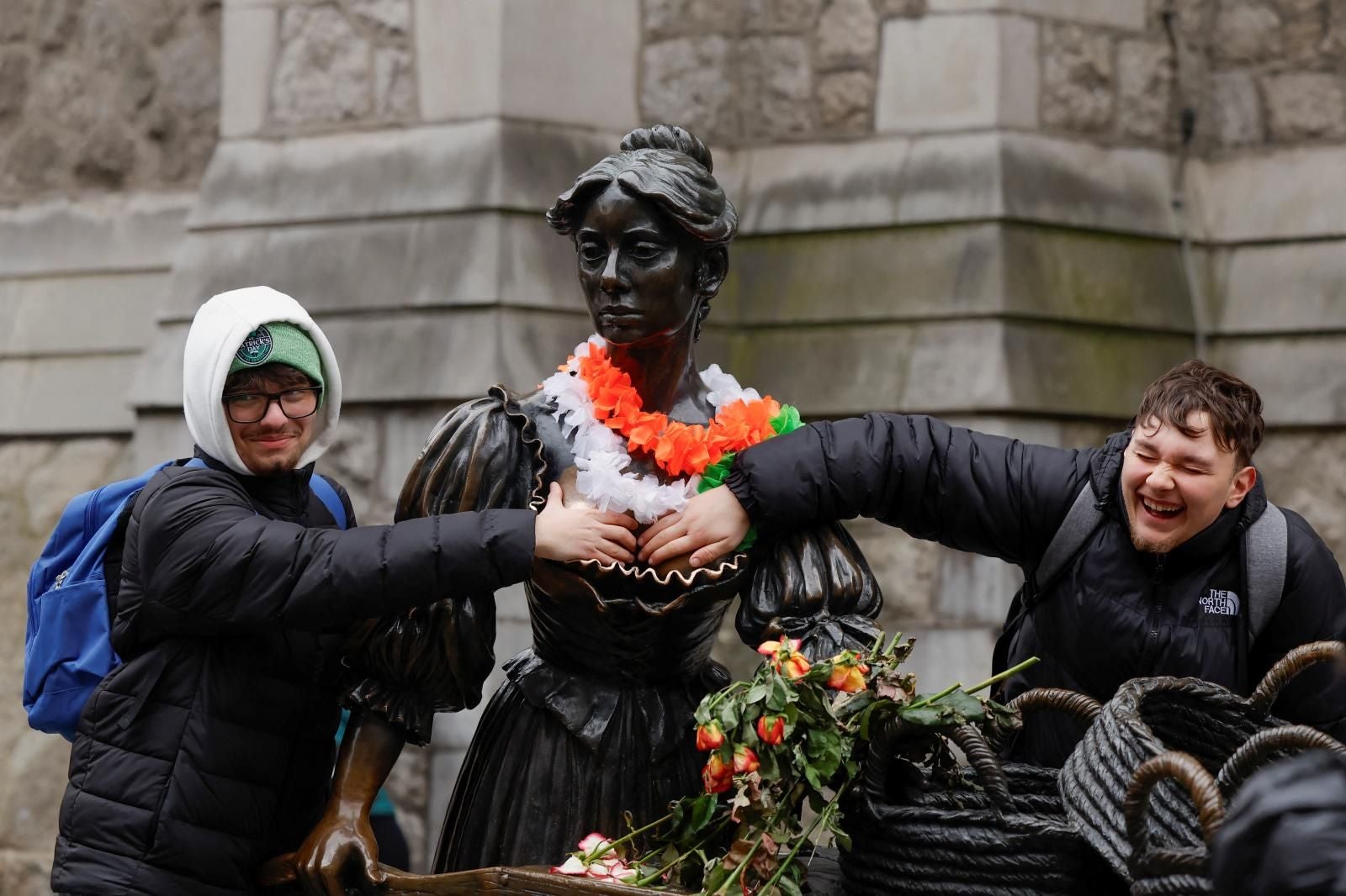 Dos personas interactúa con la estatua de Molly Malone el Día de San Patricio en Dublín en 2025