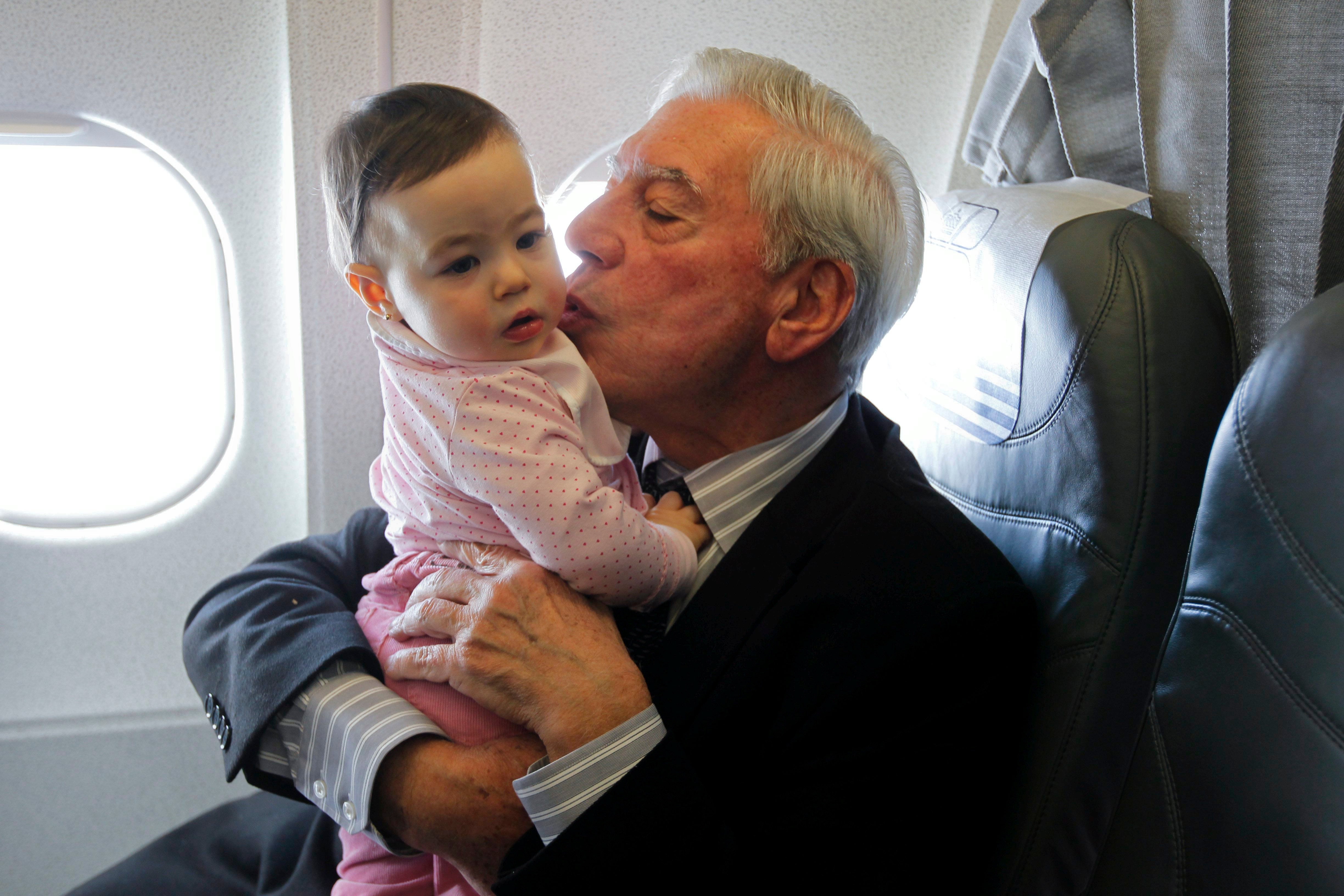 El escritor juega con su nieta Anais durante el vuelo que le trasladó a Estocolmo donde recibió el Nobel de Literatura