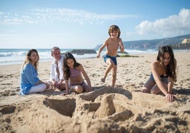 Una familia jugando a construir castillos de arena