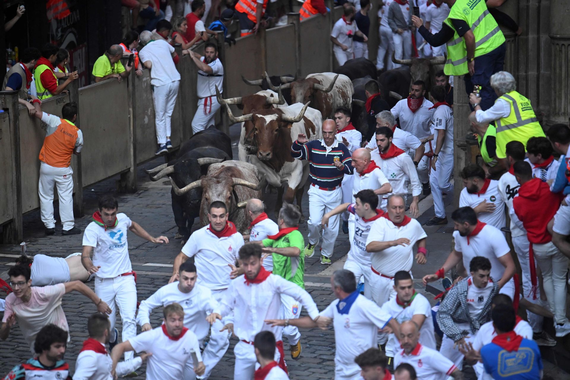 Los participantes en el encierro de San Fermín de este lunes corren delante de los Miuras en los 850 metros que llevan a la plaza de toros.