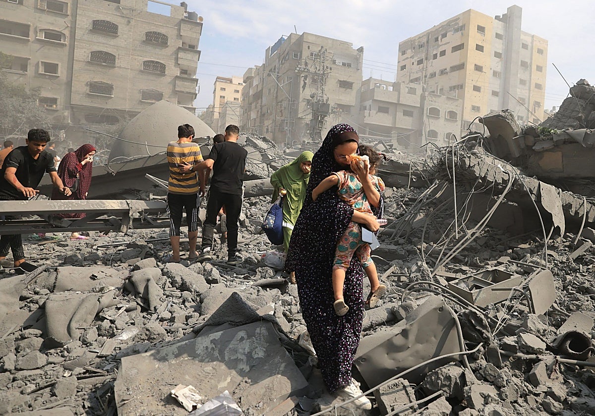 Una madre con su hijo entre las ruinas de Gaza