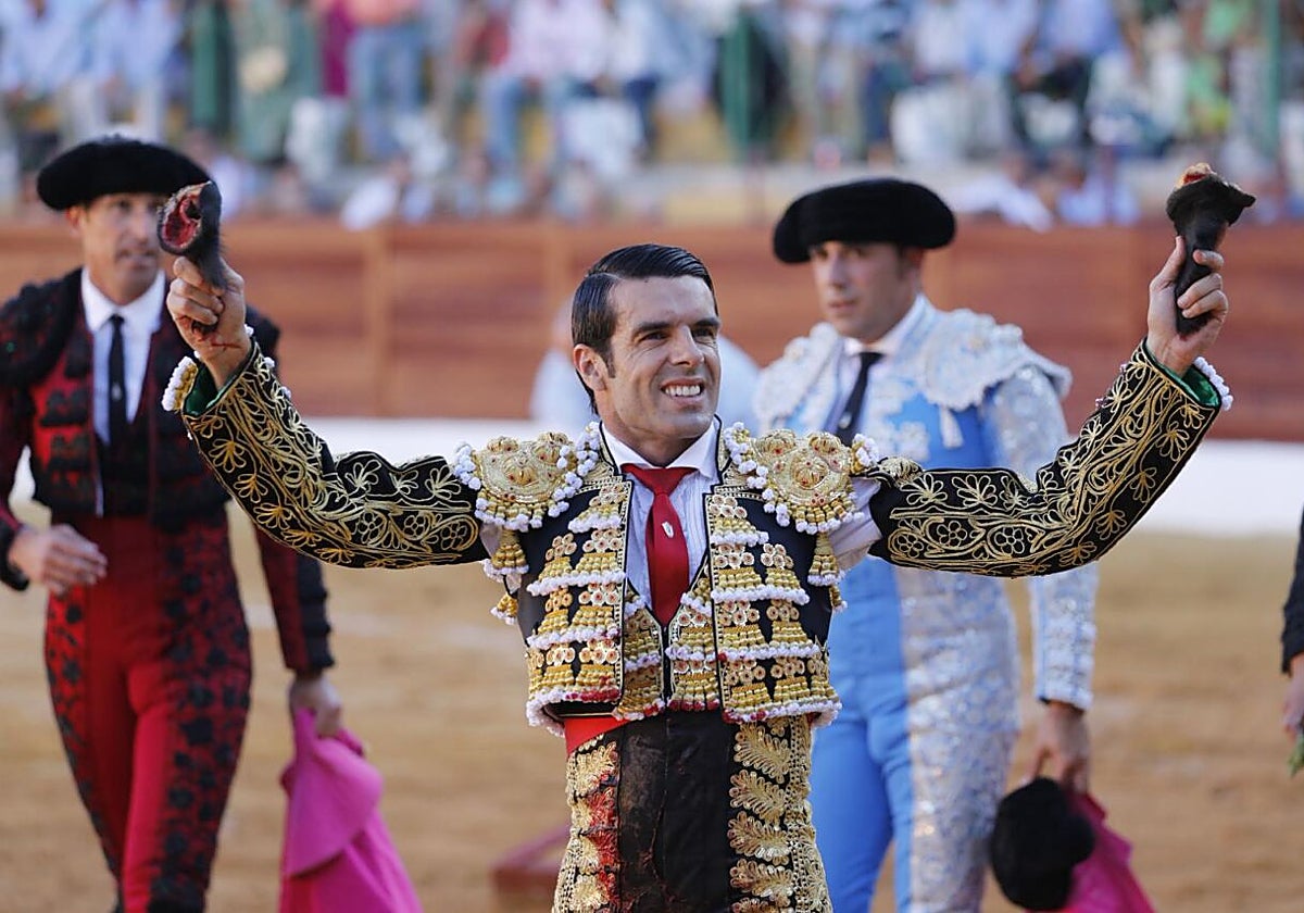 Emilio de Justo muestra dos de las orejas cortadas este domingo en La Línea