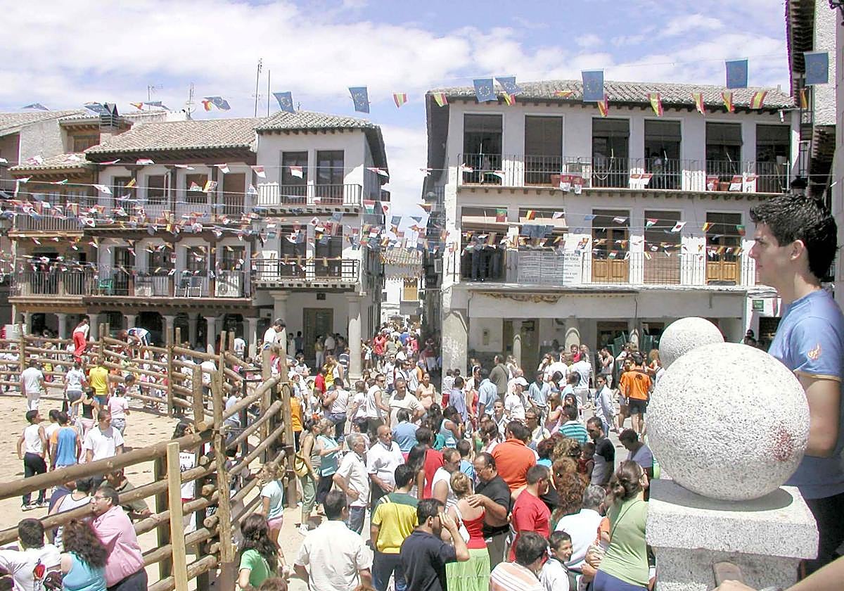 Plaza de un pueblo de España, con los banderines surcando el cielo bajo el que los mozos pasarán las fiestas