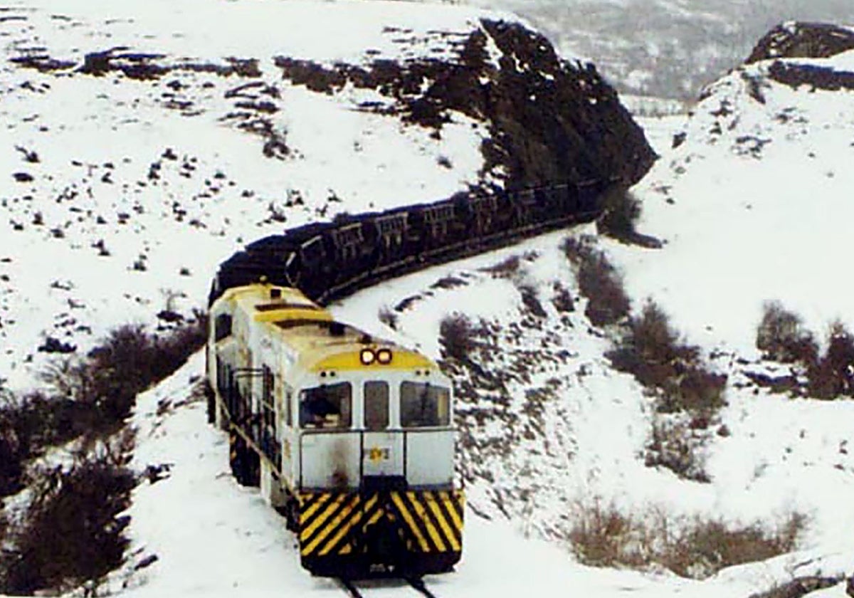 Una máquina con vagonetas de carbón atraviesa un paisaje nevado