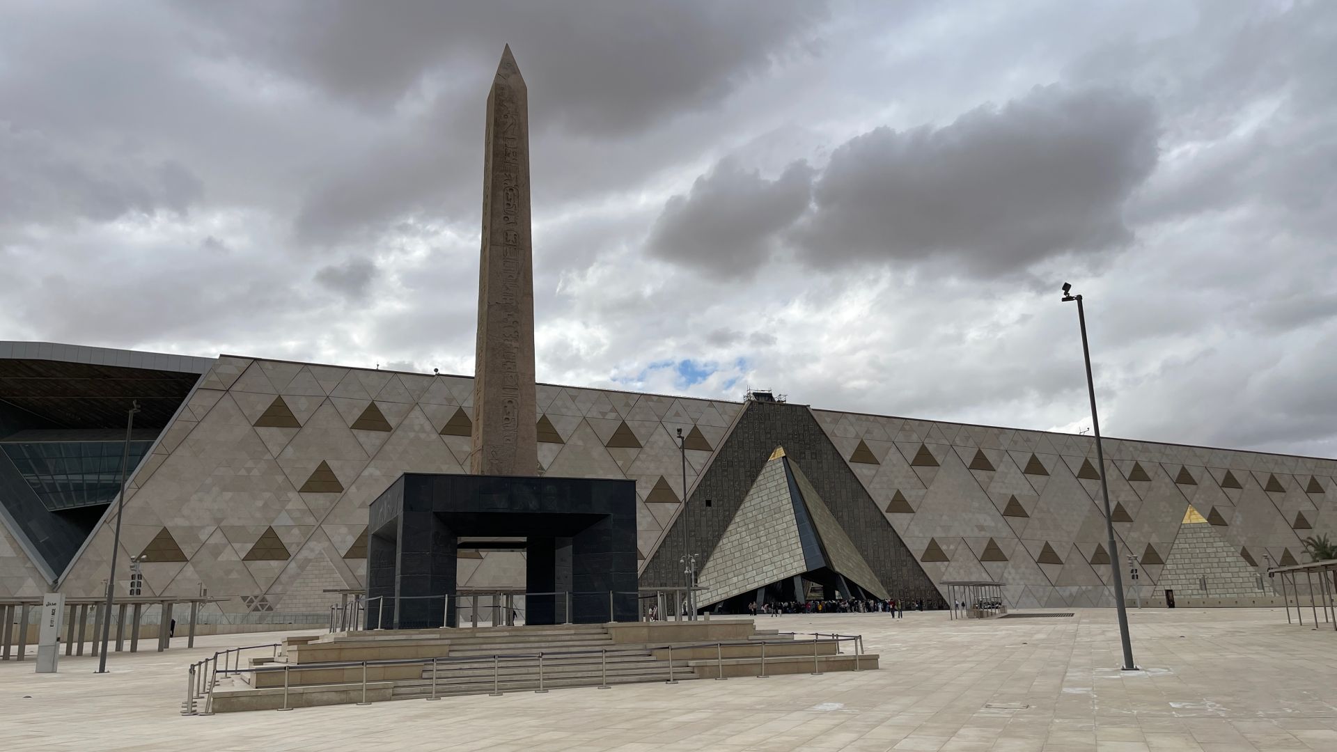 Un obelisco del faraón Ramsés II recibe a los visitantes del Gran Museo Egipcio que ya se cuentan por miles, aún antes de su inauguración oficial. La apertura escalonada del museo ha permitido la visita hasta ahora del grandioso vestíbulo, su escalinata poblada de estatuas y doce de sus salas. Con gran secretismo se han preparado las salas que mostrarán los más de 5.000 objetos del ajuar funerario de Tutankamón por primera vez desde su descubrimiento por Howard Carter en 1922.
