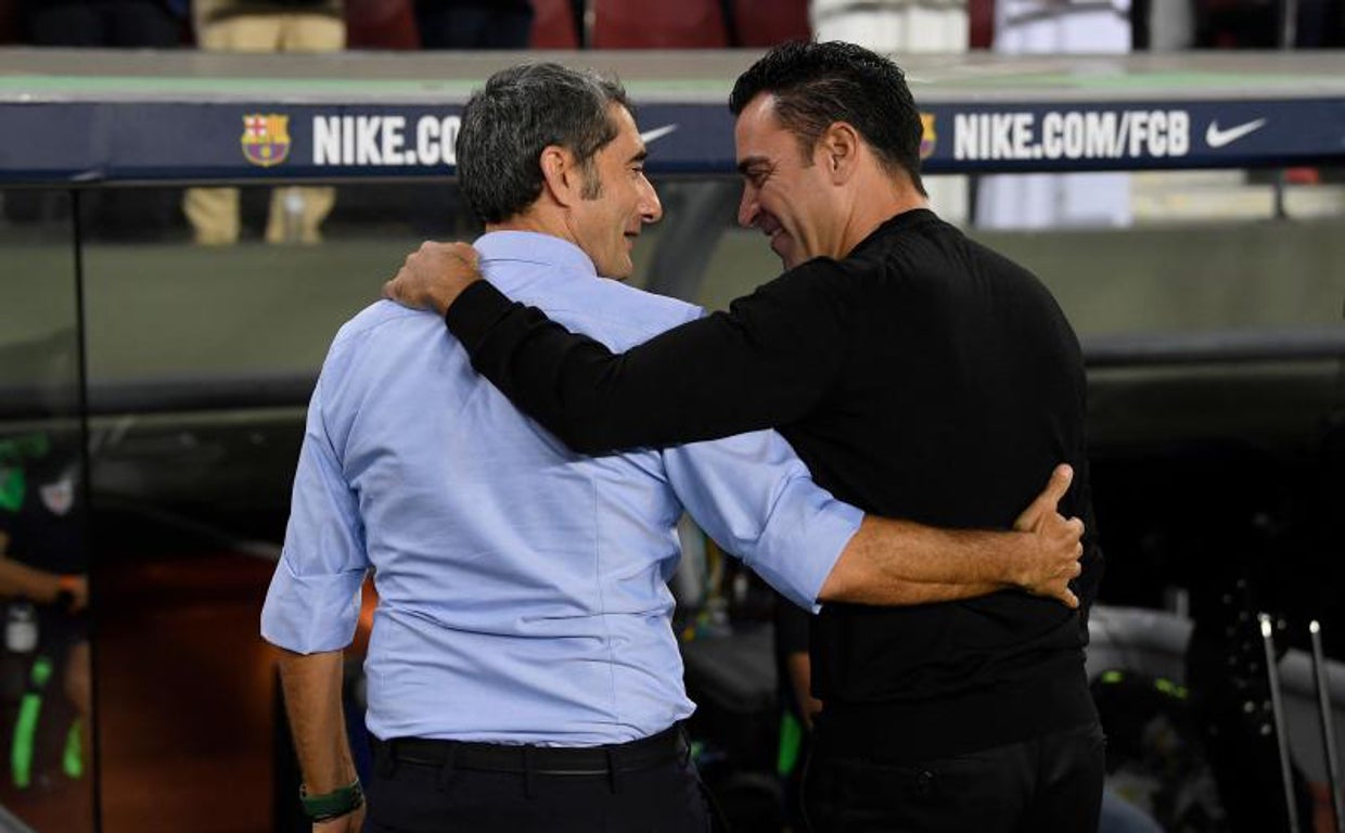 Xavi y Valverde se saludan antes del partido