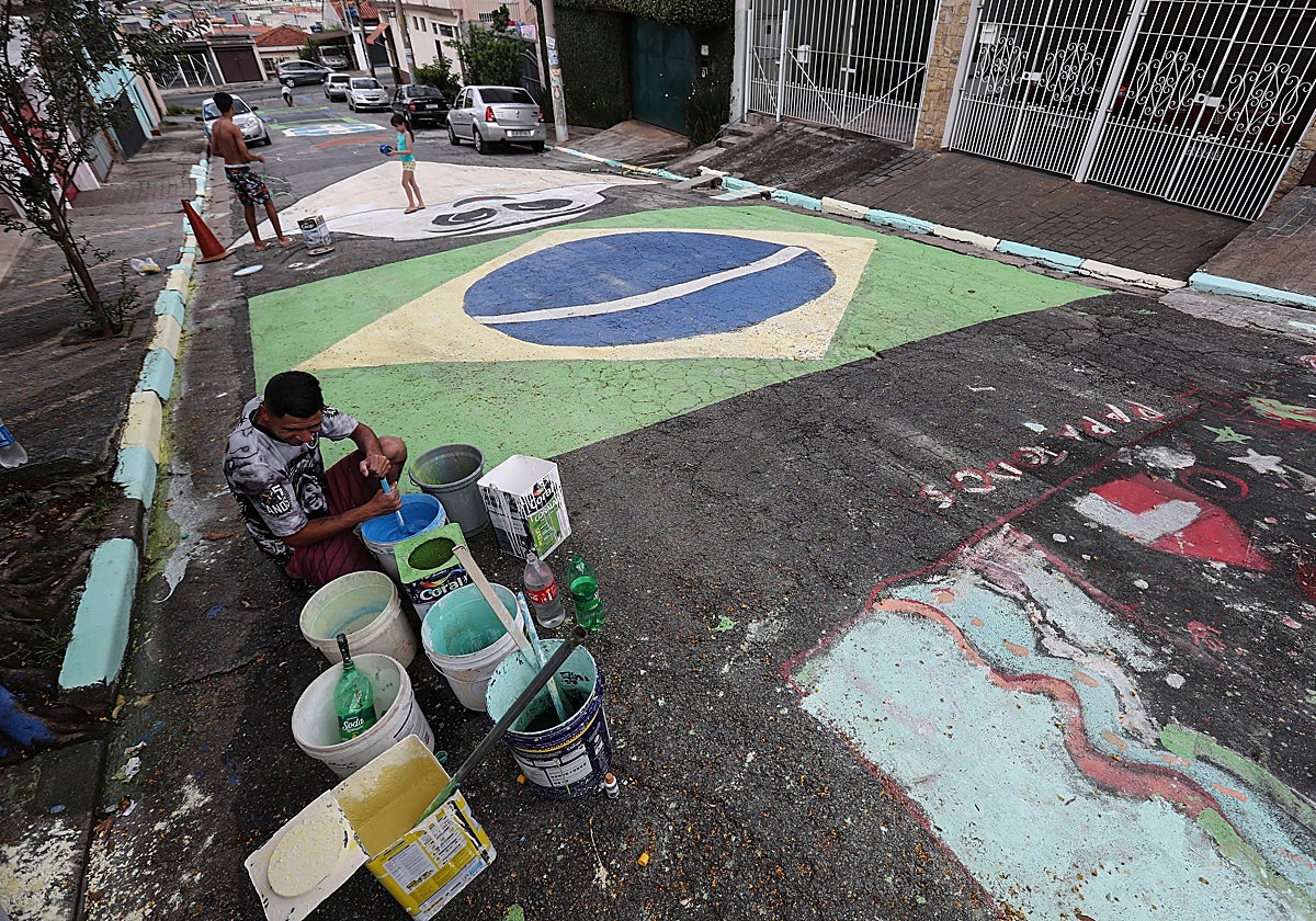 Aficionados pintan una Calle de Sao Paulo con la bandera de Brasil
