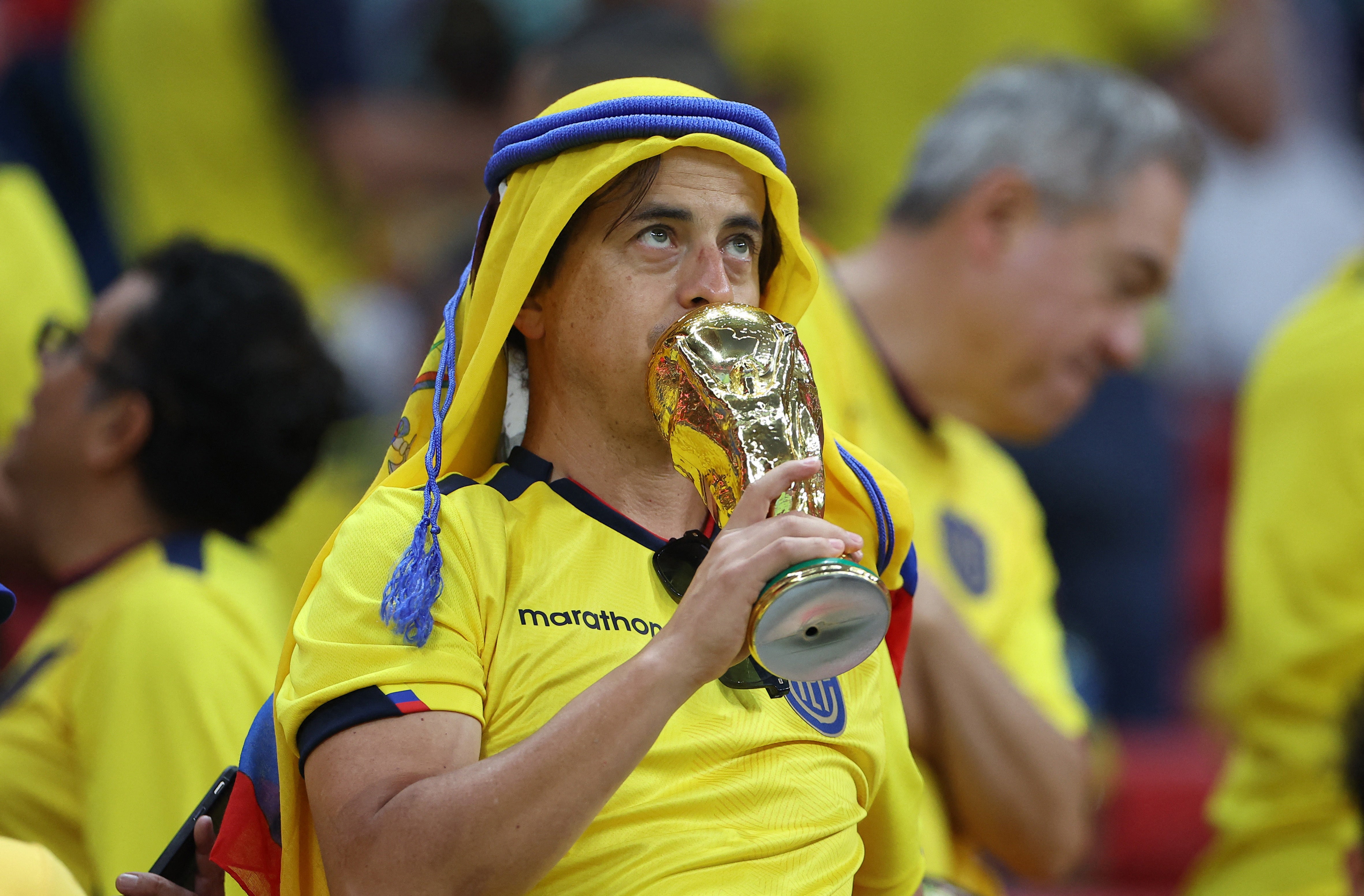 Un fan de Ecuador sostiene una copia de la copa del mundo dentro del estadio