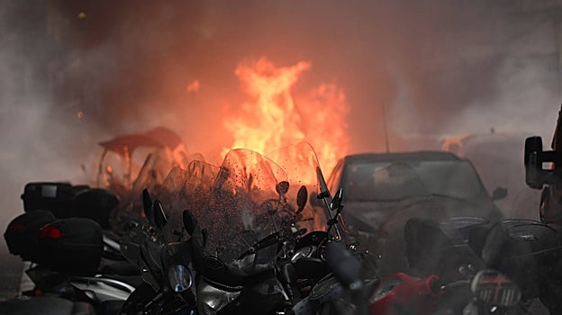 Un coche en llamas en las calles de Nápoles, consecuencia de los enfrentamientos entre ultras