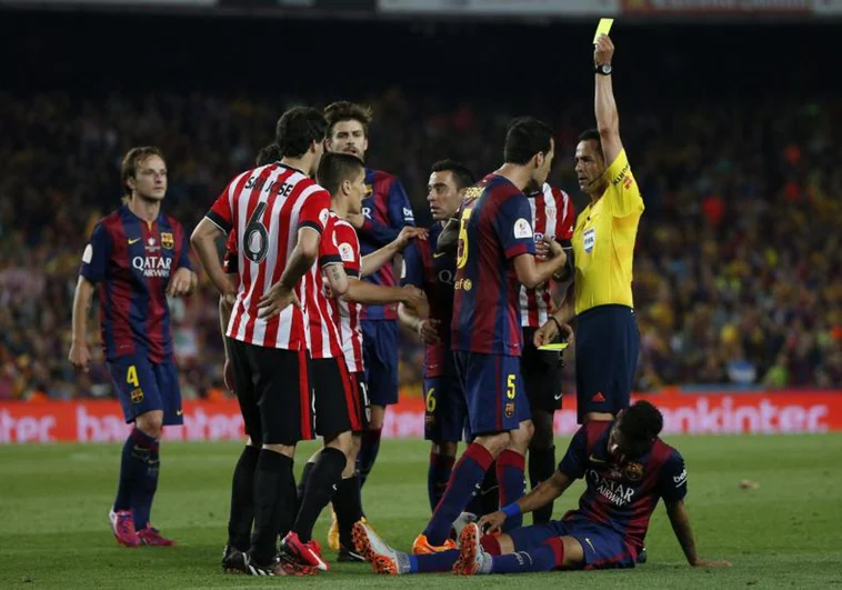 Velasco Carballo amonesta a Busquets durante la final de Copa ante el Athetic