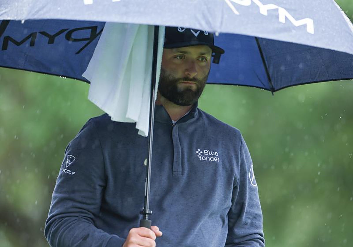 Jon Rahm se protege de la lluvia en el Masters de Augusta