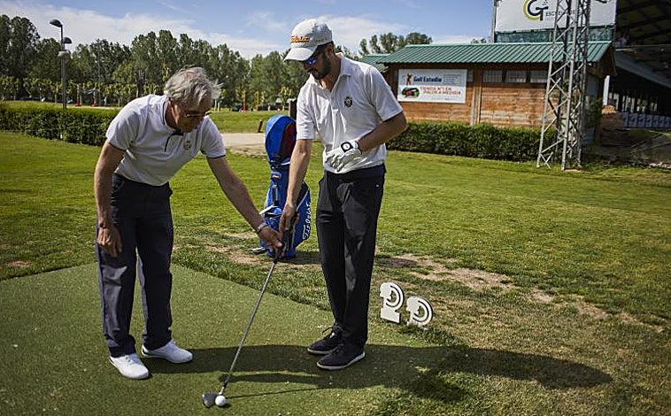 Imagen principal - La colocación, clave . Conocedor de la pegada del jugador, su guía le sugiere el palo adecuado y le coloca correctamente para que la la bola vuele en la dirección elegida.  Unidos entre golpes . Con la ayuda de un palo de golf, que cada uno agarra desde un extremo, los dos se encaminan al lugar donde tienen que efectuar el siguiente golpe.  En el green, precisión . Si la colocación en los golpes de vuelo es importante, mucho más a la hora de patear. Además, miden los pasos hasta el hoyo para calcular la fuerza